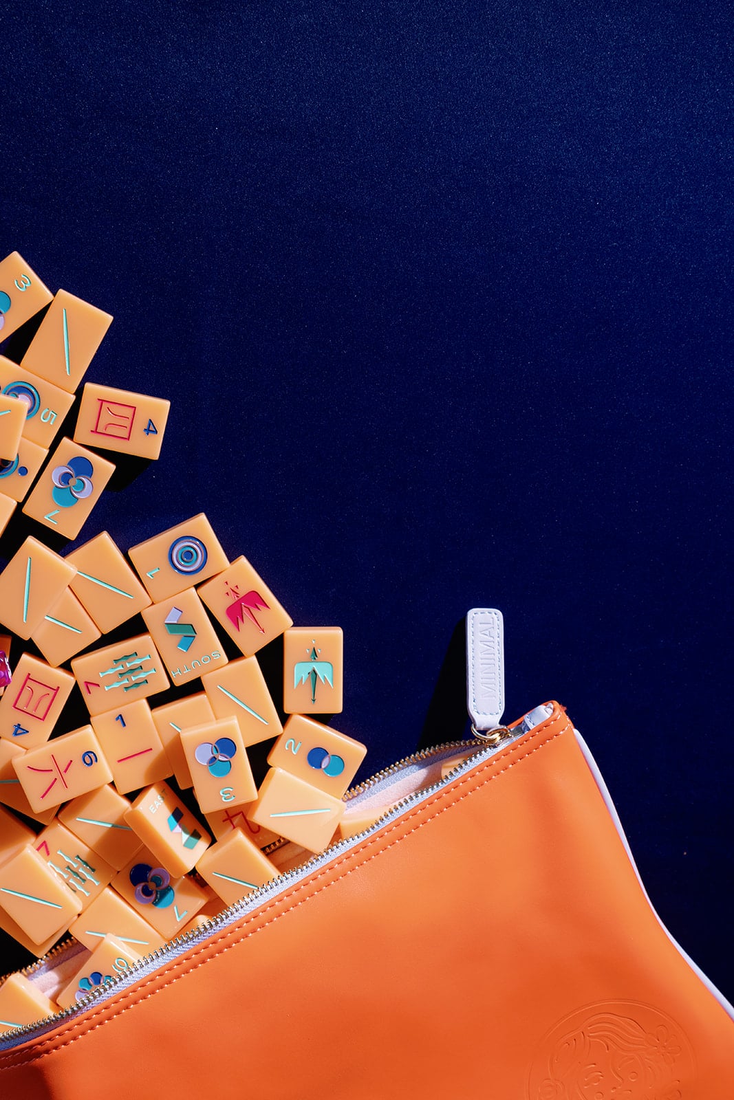 Orange mahjong tiles spilling from a zippered case