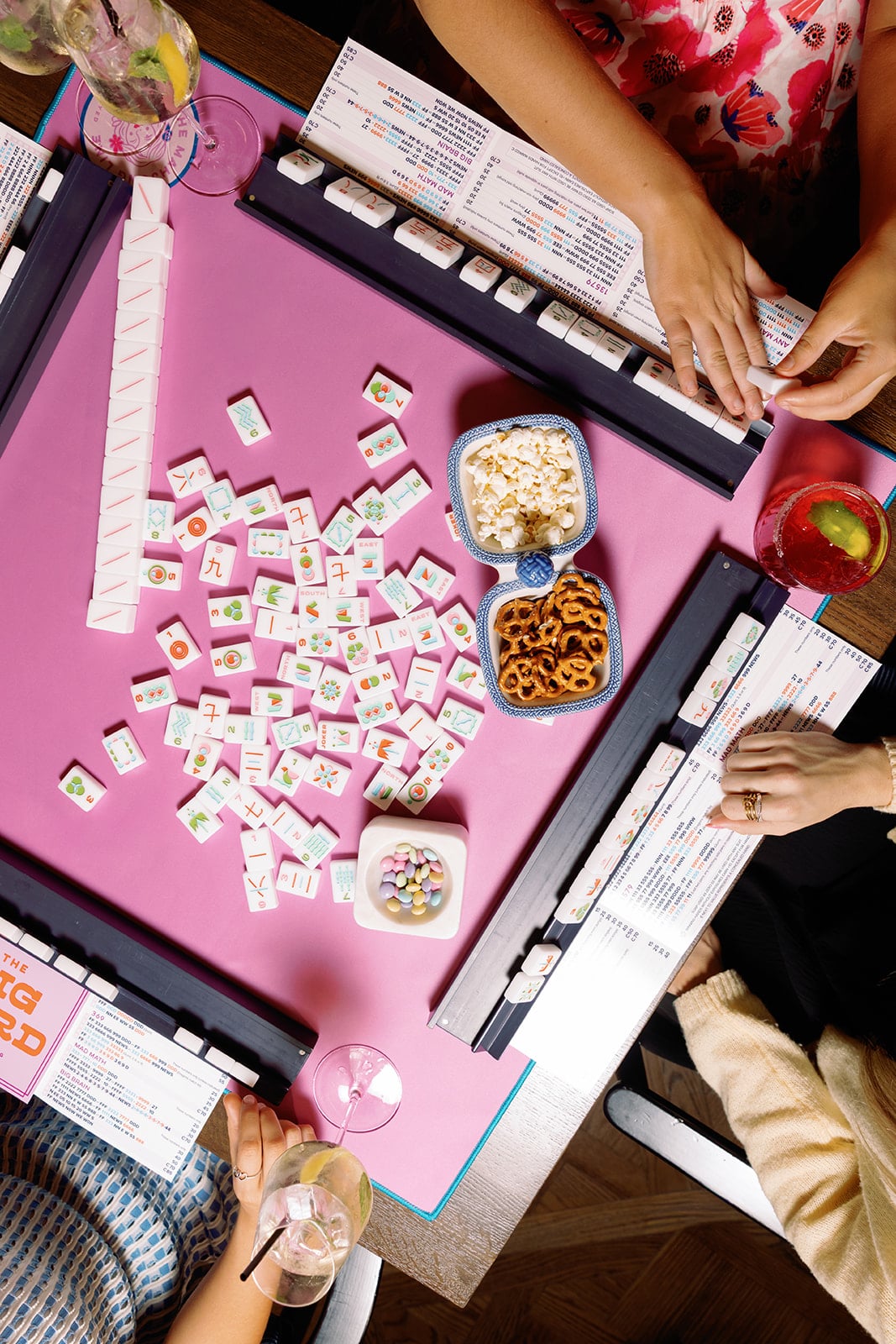 Players gathered around a pink mahjong table