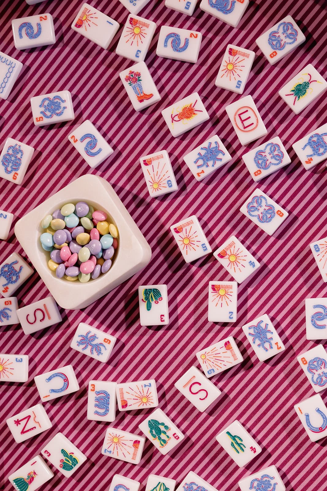 Colorful mahjong tiles arranged on a striped table